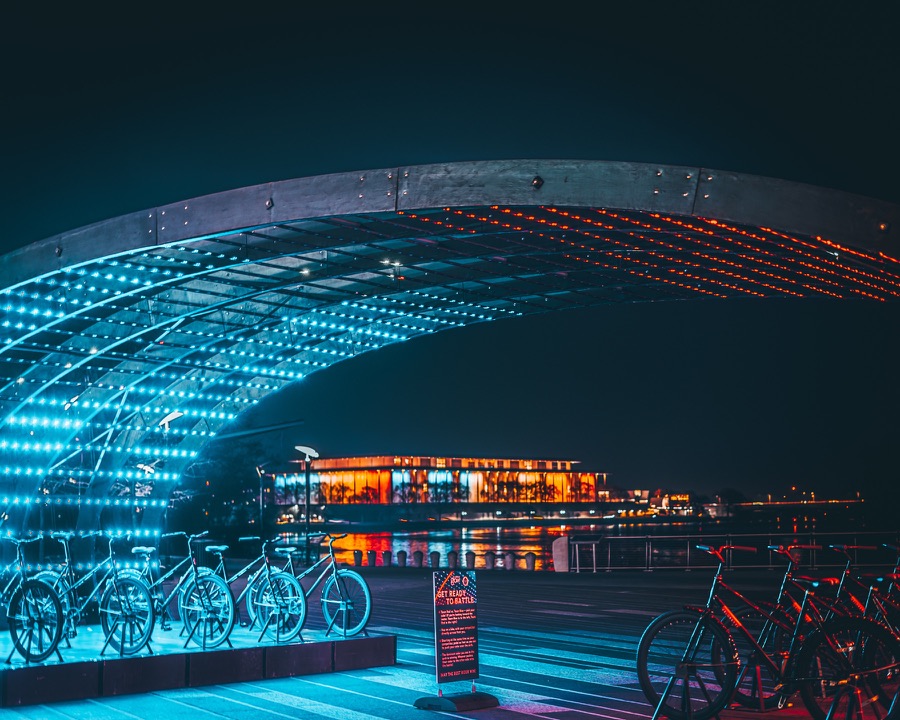 Night waterfront scene with glowing blue and orange lights